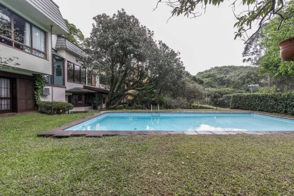 Casa rodeada por verde em rua fechada, tranquila e segura