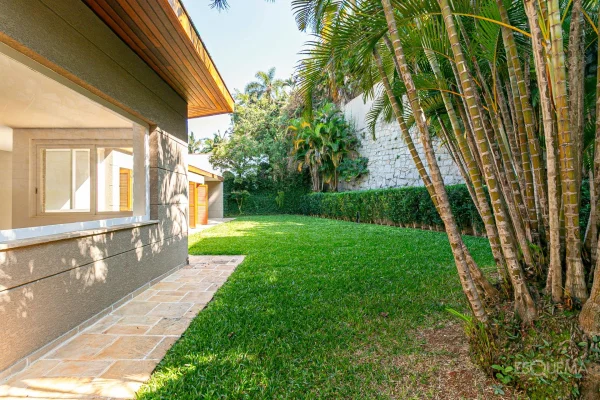 Casa térrea reformada, cercada por verde